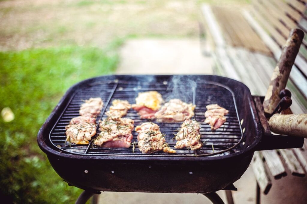 Houtskool BBQ huren met vlees op het rooster