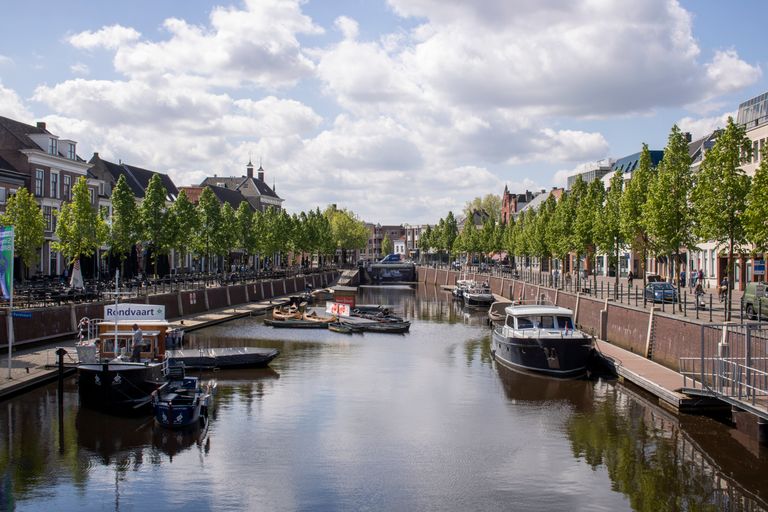 Charming view of boats along the canal in Breda, Netherlands, surrounded by historic architecture.