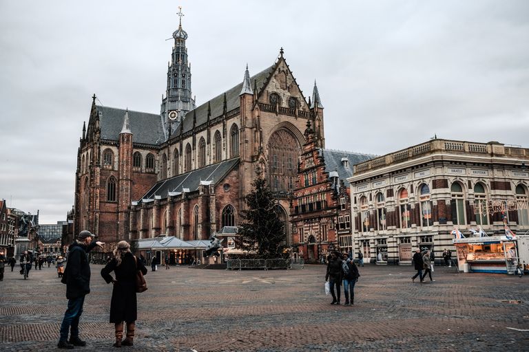 Scenic view of a historic church and lively square in Haarlem, Netherlands.