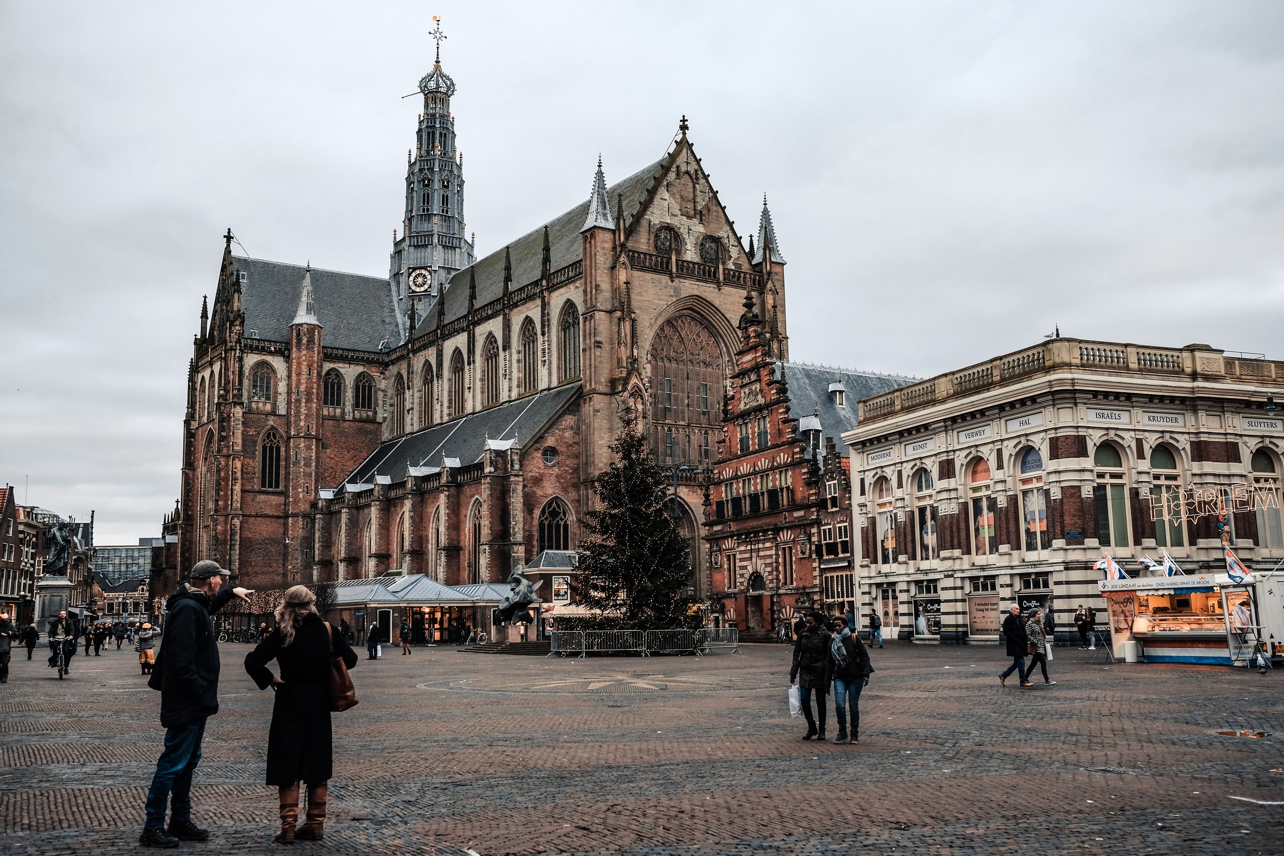 Scenic view of a historic church and lively square in Haarlem, Netherlands.