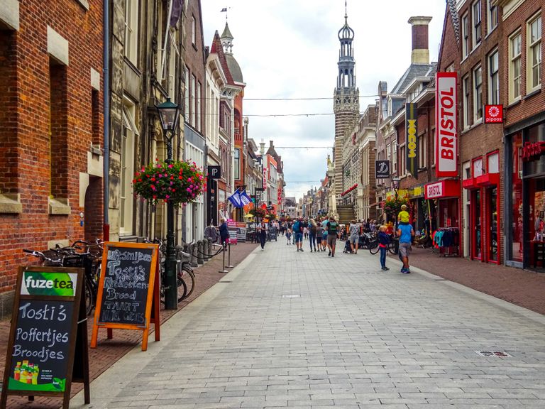 Vibrant street scene in Alkmaar, Netherlands, featuring historic architecture and lively shops.
